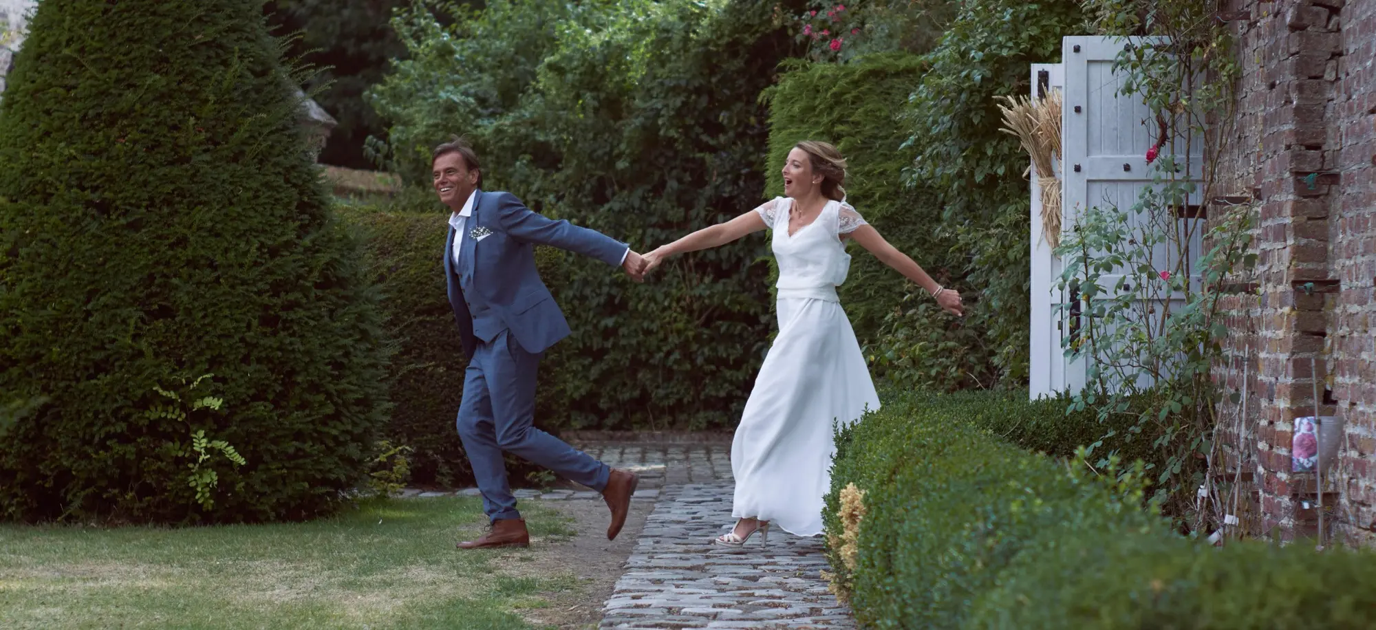 Couple de mariés courant dans un jardin à Tournai